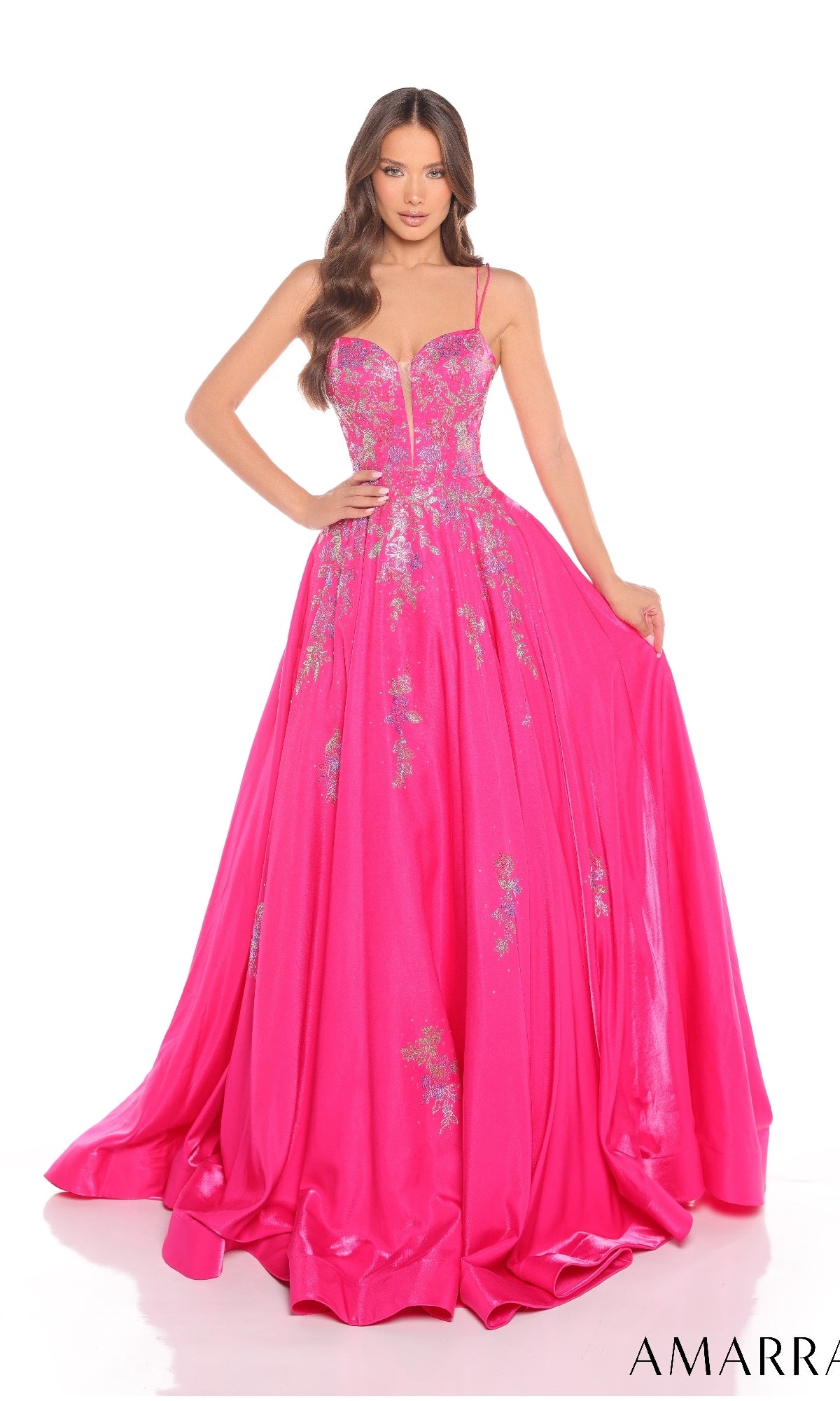 A woman models the Long Prom Dress: Amarra 88379, a bright pink floor-length gown with silver floral embellishments and spaghetti straps, against a white background.